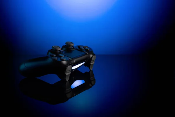 青の背景にバックライト付きブラックゲームパッド 光沢のある表面にジョイスティック — ストック写真