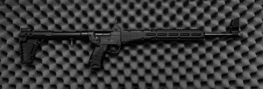 Gri köpük kauçuk arka planda küçük yarı otomatik silah. Polis ve özel kuvvetler için küçük çaplı silahlar. Katlanan karabina.