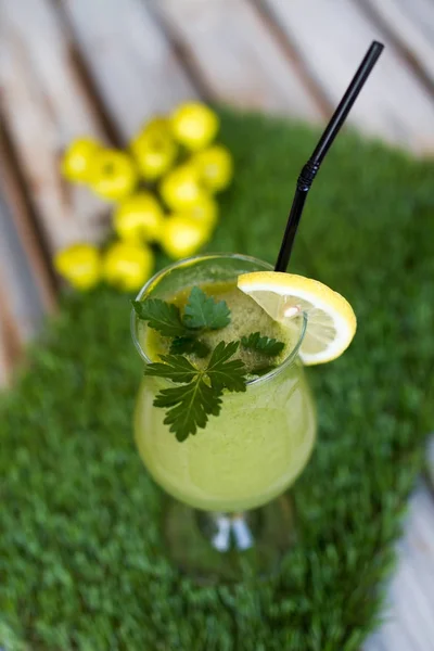 Un vaso de jugo de piña en una servilleta verde —  Fotos de Stock