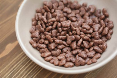 Mısır gevreği kalp ahşap arka plan bej plaka şeklinde