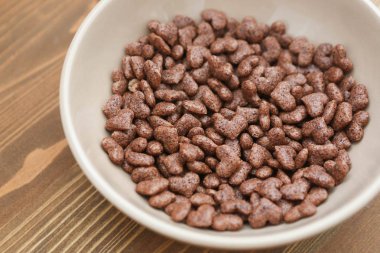 Mısır gevreği kalp ahşap arka plan bej plaka şeklinde