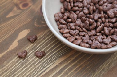 Mısır gevreği kalp ahşap arka plan bej plaka şeklinde