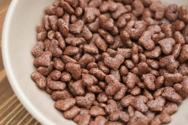 Mısır gevreği kalp ahşap arka plan bej plaka şeklinde