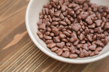 Mısır gevreği kalp ahşap arka plan bej plaka şeklinde