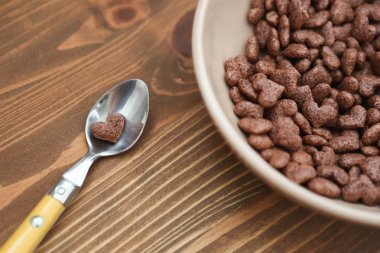 Cornflake kalp şeklinde ahşap kahverengi zemin kaşık yatıyor