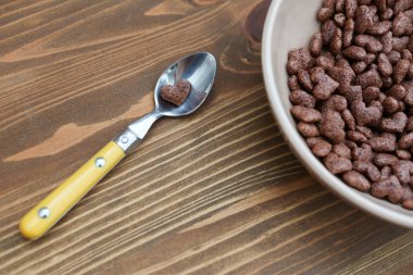 Cornflake kalp şeklinde ahşap kahverengi zemin kaşık yatıyor