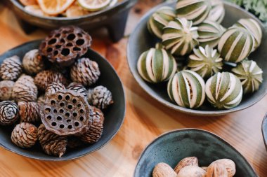 Noel çelengi için üs. Noel süsleri. Çiçekçi Noel çelengi yapıyor. Kadın eli görmek çelenk yapar. Çelenk süslemeleri. Portakallar, çiçekler kırmızı böğürtlenler, ahşap yıldızlar.