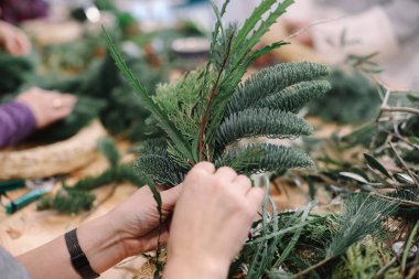 Noel çelengi için üs. Noel süsleri. Noel çelengi. Çiçekçi Noel çelengi yapıyor. Kadın eli görünümü çelenk yapar..