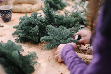 Noel çelengi için üs. Noel süsleri. Noel çelengi. Çiçekçi Noel çelengi yapıyor. Kadın eli görünümü çelenk yapar..