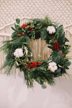 Noel süsleri. Noel çelengi. Çiçekçi Noel çelengi yapıyor. Çelenk tutan kadın eli görüntüsü.