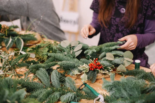 Base for Christmas wreath. Christmas decorations. Christmas wreath. Florist making Christmas wreath. View of female hands make a wreath.