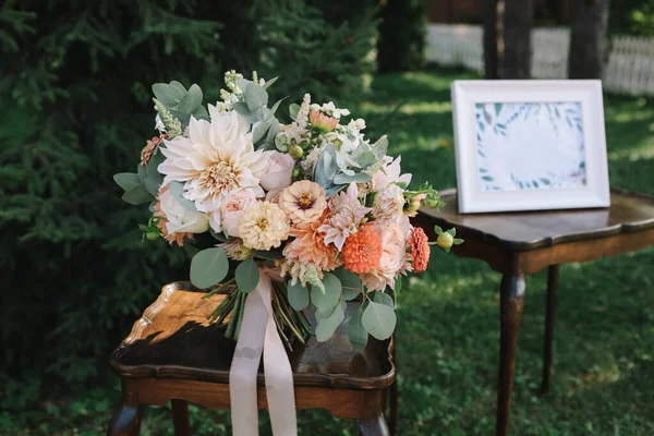 新娘的结婚花束由粉色 红色和橙色的花朵组成 放在木制桌子上 — 图库照片