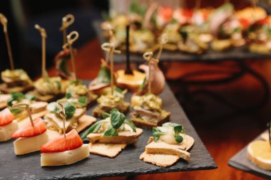Ziyafet servisi. Farklı hafif atıştırmalıklarla birlikte açık büfe tarzı meyveler ve sebzeler, et, havyar ve şarap..