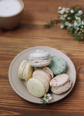 Kahverengi ahşap arka planda renkli ev yapımı makaronlar var. Bir fincan kahve.. 
