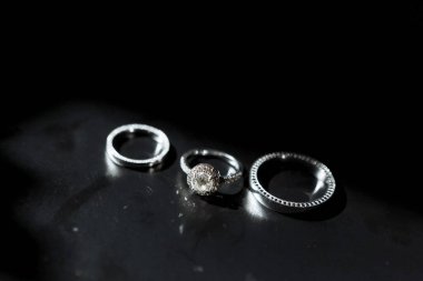 Siyah arka planda 3 altın yüzük. Düğün..