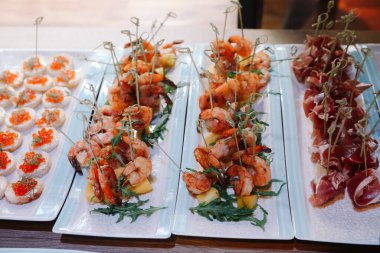 Ziyafet servisi. Kırmızı havyarlı sandviçler, karides, balon