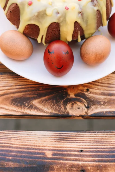 Yumurtaların Etrafında Bir Gülümsemeyle Kırmızı Paskalya Yumurtası Ahşap Arka Planda — Stok fotoğraf