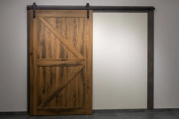 The door to nowhere. Sliding wooden door in the loft style with