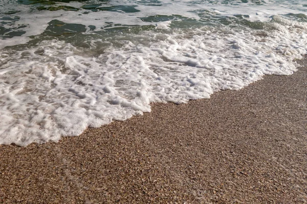 Tidal bore. A wave runs onto a sandy beach. Autumn sea. Sea wave