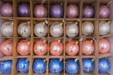 Bir mağaza rafındaki ambalajda farklı şekillerde ve renklerde Noel ağacı süslemeleri. 2019.04.12. Odessa 'da. Ukrayna.