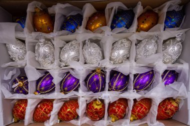 Bir mağaza rafındaki ambalajda farklı şekillerde ve renklerde Noel ağacı süslemeleri. 2019.04.12. Odessa 'da. Ukrayna.