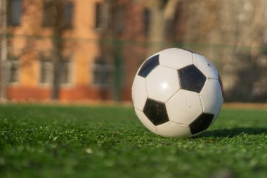 Yapay bir sahada açık bir alanda siyah beyaz bir futbol topu.