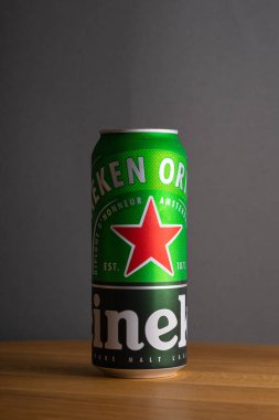 Siyah ve yeşil Heineken birası. Gri arka planda meşe ağacından bir masada. Odessa 'da. Ukrayna. 2019.12.20.