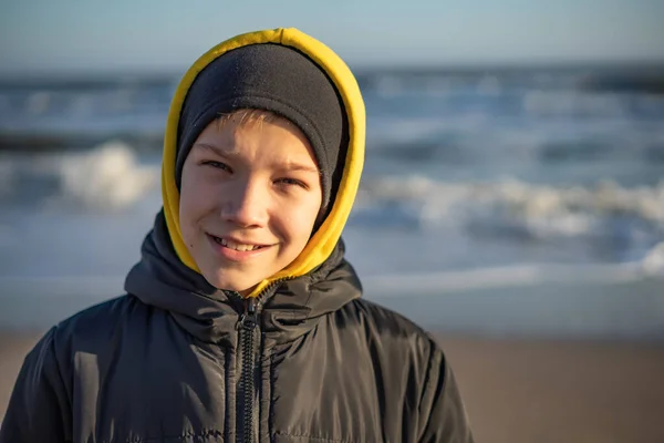 Πορτρέτο ενός 10χρονου αγοριού δίπλα στη θάλασσα μια ηλιόλουστη χειμωνιάτικη μέρα. — Φωτογραφία Αρχείου
