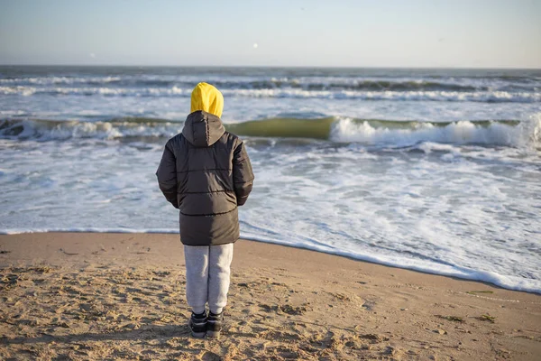 Πορτρέτο ενός 10χρονου αγοριού δίπλα στη θάλασσα μια ηλιόλουστη χειμωνιάτικη μέρα. — Φωτογραφία Αρχείου