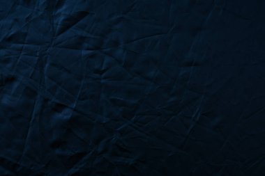 Texture of crumpled black fabric with a blue tint. Creative vint