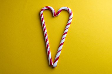 Peppermint candy canes on a yellow background.