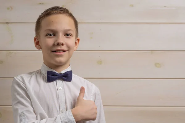 Egy 10 éves szőke fiú fehér ingben, önnyakkendővel. — Stock Fotó