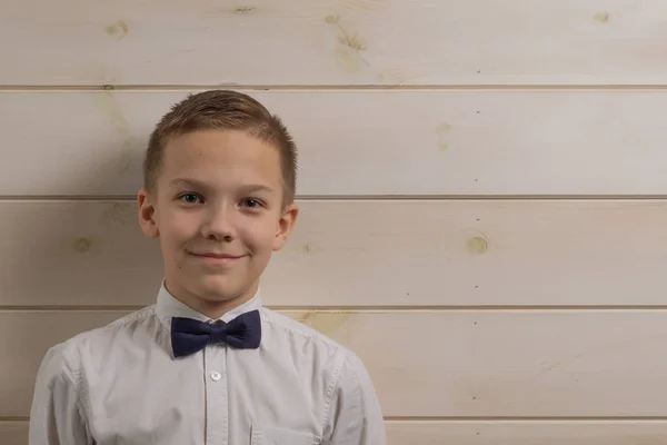 Egy 10 éves szőke fiú fehér ingben, önnyakkendővel. — Stock Fotó
