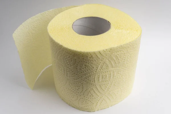 Rolka żółtego teksturowanego papieru toaletowego tłoczonego na białym tle — Zdjęcie stockowe