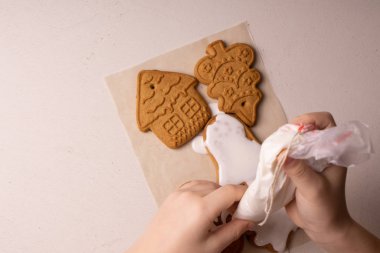 10 yaşında bir çocuk mutfak çantasıyla kurabiye parlatıyor. El yapımı. Çocukların yaratıcılığı.