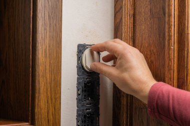 Soket Kurulumu. Usta bir elektrikçi klasik bir iç mekâna bir elektrik konnektörü yerleştirir..