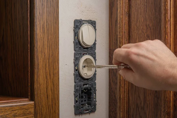 Installation de prise. Un maître électricien installe un connecteur électrique dans un intérieur classique . — Photo