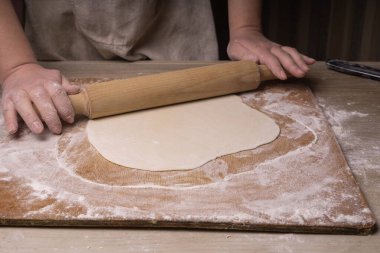 Bir kadın hamur topluyor. Çizgi film tahtası, ahşap un