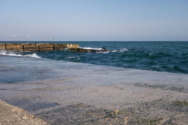 Беспокойное море, бетонный пирс, волны, чайки . — стоковое фото