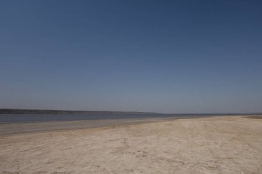 Kumlu göl kıyısı Bulutsuz rüzgarlı bir günde
