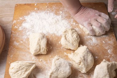 Ev mutfağında hamur karıştıran kadın elleri.