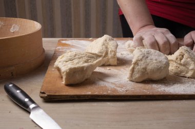 Ev mutfağında hamur karıştıran kadın elleri.