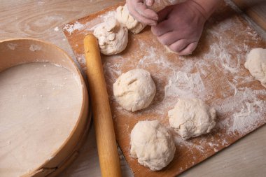 Ev mutfağında hamur karıştıran kadın elleri.