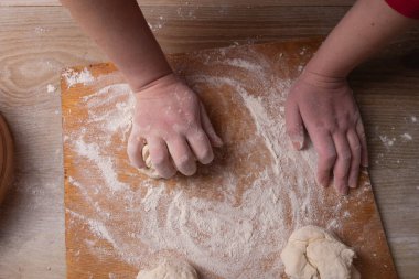 Ev mutfağında hamur karıştıran kadın elleri.