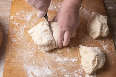 Ev mutfağında hamur karıştıran kadın elleri.