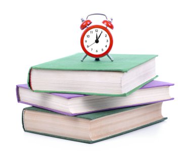 Kırmızı alarm saati ve beyaz arka plan üzerinde izole kitap yığını