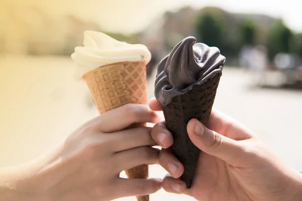 Vrouw handen bedrijf smeltende wafel ijsje in handen op de zomer licht stad achtergrond. Prettige vakantie concept. Close-up foto. — Stockfoto