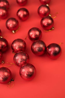 Kırmızı arka planda kırmızı Noel süslemeleri. Yeni yıl tebrik kartı. Asgari düzeyde. Düz yatıyordu.