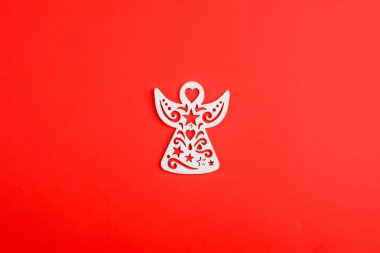 Kırmızı arka planda beyaz Noel meleği süsü, yeni yıl oyuncakları. Xmas.