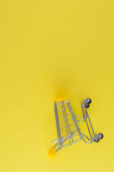 Piccolo carrello della spesa su sfondo giallo posto libero per il testo — Foto Stock